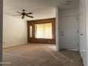 Bright living room with wood paneling and neutral carpet at 702 W Grove Cir, Mesa, AZ 85210