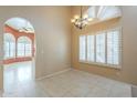 Bright dining area features tile flooring, a chandelier, plantation shutters, and an open layout at 9288 E Camino Del Santo --, Scottsdale, AZ 85260