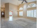 Spacious living room with neutral carpeting, plantation shutters, a ceiling fan, and access to other rooms at 9288 E Camino Del Santo --, Scottsdale, AZ 85260