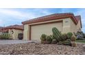 Close-up of a home's garage with cacti in front at 14131 W Circle Ridge Dr, Sun City West, AZ 85375