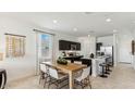 Light and bright dining area with wood table and white chairs at 1714 W Spaulding Ave, Apache Junction, AZ 85120