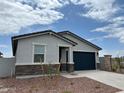 Single-story home showcasing stone accents, a two-car garage, and minimalistic desert landscaping at 17457 W Eva St, Waddell, AZ 85355