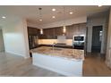 Well-appointed kitchen featuring an island with a sink, granite countertops, and modern appliances at 19315 W Luke Ave, Litchfield Park, AZ 85340