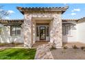 Inviting house entrance with stone accents and a glass door at 21086 E Mewes Rd, Queen Creek, AZ 85142