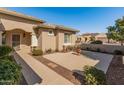 Courtyard entry with stone pathway, potted plants, and wrought-iron gate at 26458 W Yukon Dr, Buckeye, AZ 85396