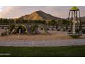 Modern playground with unique climbing structures and a spinning toy, set against a mountain backdrop at 3390 W Sunstone Dr, San Tan Valley, AZ 85144