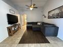 Comfortable living room with a ceiling fan, tile flooring, and entertainment center for relaxation at 3560 W Tina Ln, Glendale, AZ 85310