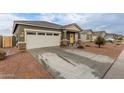 Green house with a two-car garage and a front yard at 36060 W Santa Clara Ave, Maricopa, AZ 85138