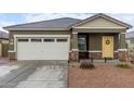 Newly built home with a two-car garage and yellow door at 36060 W Santa Clara Ave, Maricopa, AZ 85138