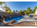 Inviting backyard pool with patio furniture and rock waterfall feature at 4202 S 76Th Ln, Phoenix, AZ 85043