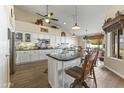 Large kitchen with granite island, white cabinets, and wood floors at 4644 W Soft Wind Dr, Glendale, AZ 85310