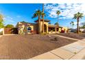 Tan house with a large front yard, palm trees, and a walkway to the entrance at 6030 E Crocus Dr, Scottsdale, AZ 85254