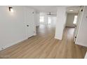 Bright hallway with light wood flooring, leading to other rooms at 634 E Calavar Rd, Phoenix, AZ 85022