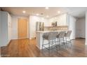 Modern kitchen with white cabinets, island seating, and hardwood floors at 7137 E Rancho Vista Dr # 6010, Scottsdale, AZ 85251