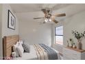Well-lit bedroom with ceiling fan, natural light, cozy decor, and calming color scheme at 8728 W Vale Dr, Phoenix, AZ 85037