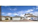 White house with a two-car garage and a gravel driveway at 8728 W Vale Dr, Phoenix, AZ 85037