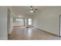 Living room with tile floors, sliding glass door, and ceiling fan at 8728 W Vale Dr, Phoenix, AZ 85037