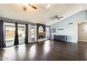 Spacious living room featuring vaulted ceilings, wood floors, and a cozy fireplace at 8818 W Virginia Ave, Phoenix, AZ 85037