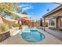 Inviting backyard pool area with stone surround, covered patio, and shade sails at 8818 W Virginia Ave, Phoenix, AZ 85037