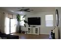 Bright living room featuring a large TV and sliding glass doors at 9024 W Alda Way, Peoria, AZ 85382