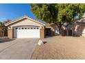 House exterior featuring a white garage door and a rock in the front yard at 956 W Hudson Way, Gilbert, AZ 85233