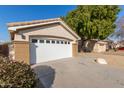 Single story home with a white garage door and drought-tolerant landscaping at 956 W Hudson Way, Gilbert, AZ 85233