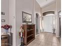 Bright and airy entryway with tile flooring and a wooden bookshelf at 13450 W Maui Ln, Surprise, AZ 85379