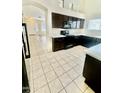 Kitchen boasts dark wood cabinets, white countertops, and stainless appliances at 13622 W Peck Ct, Litchfield Park, AZ 85340