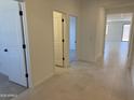 Bright hallway features neutral tile flooring and leads to various rooms in the home at 20596 N 226Th Dr, Surprise, AZ 85387