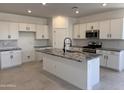 Modern kitchen with white cabinetry, stainless steel appliances, a gray granite island, and tile flooring at 20596 N 226Th Dr, Surprise, AZ 85387