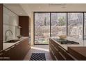 Gourmet kitchen with an island cooktop, stainless steel appliances, and scenic backyard views at 5000 N Camelback Ridge Rd # 109, Scottsdale, AZ 85251