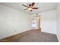 Neutral bedroom with carpet, ceiling fan, white walls, and an open door leading to other rooms at 5450 E Deer Valley Dr # 4015, Phoenix, AZ 85054