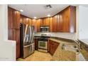 Cozy kitchen featuring stainless steel appliances, granite countertops, and dark wood cabinets at 5450 E Deer Valley Dr # 4015, Phoenix, AZ 85054