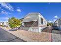 Mobile home with covered awning, a tree, and paved driveway at 7750 E Broadway Rd # 309, Mesa, AZ 85208