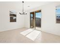 Bright dining area with tile floors and sliding glass door leading to backyard at 8643 W Albeniz Pl, Tolleson, AZ 85353