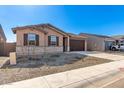 New construction home with a large driveway and stone facade at 8643 W Albeniz Pl, Tolleson, AZ 85353