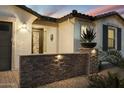 Elegant entryway with stone wall, lighting, and landscaping at 12528 W Tuckey W Ln, Glendale, AZ 85307