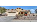 Tan house with a two-car garage and front porch at 1378 E Madison Dr, Casa Grande, AZ 85122