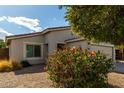 House with tan colored exterior and red flowers in front at 1615 E Maddison Cir, San Tan Valley, AZ 85140