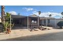 Tan mobile home with carport and landscaping at 2233 E Behrend Dr # 61, Phoenix, AZ 85024