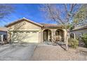 Tan house with arched entryway, two-car garage, and desert landscaping at 2524 W Saint Catherine Ave, Phoenix, AZ 85041