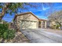 Tan house with arched entryway, two-car garage, and desert landscaping at 2524 W Saint Catherine Ave, Phoenix, AZ 85041