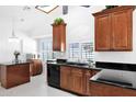 Well-lit kitchen with granite countertops, black appliances and wooden cabinets at 3352 E Hopi Ave, Mesa, AZ 85204