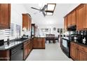 Well-lit kitchen with granite countertops, black appliances and white tiled floors at 3352 E Hopi Ave, Mesa, AZ 85204