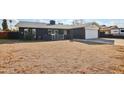 Dark-colored single story home with a spacious front yard at 5013 W Orchid Ln, Glendale, AZ 85302