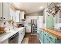 Beautiful kitchen featuring a farmhouse sink, stainless steel appliances, and a green kitchen island at 9713 E Onza Ave, Mesa, AZ 85212