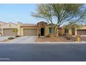 Front view of a single-story home with a two-car garage and desert landscaping at 16918 W Palm Ln, Goodyear, AZ 85395