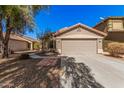 Charming single-story home featuring a two-car garage and desert landscaping at 44520 W Windrose Dr, Maricopa, AZ 85138