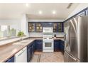 Bright kitchen with stainless steel appliances and dark blue cabinets at 44520 W Windrose Dr, Maricopa, AZ 85138