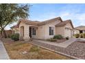 Tan house with a two-car garage, walkway, and desert landscaping at 5241 E Ingram St, Mesa, AZ 85205